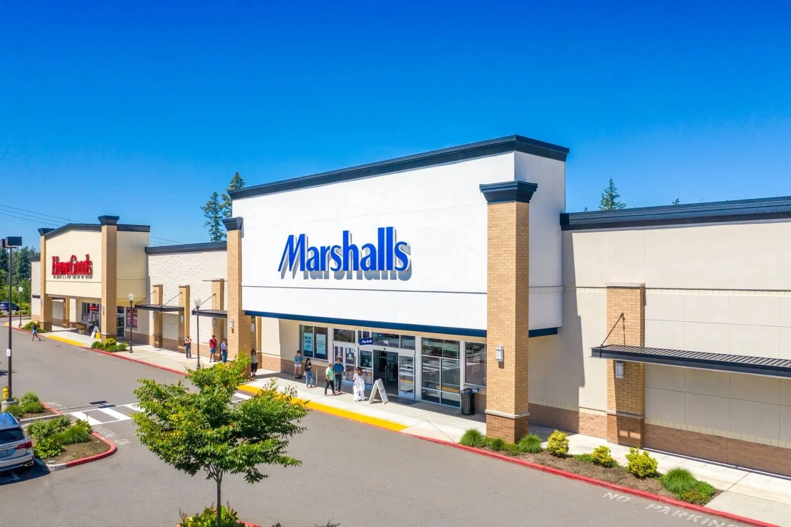 Long single story retail building with a storefront and parking lot