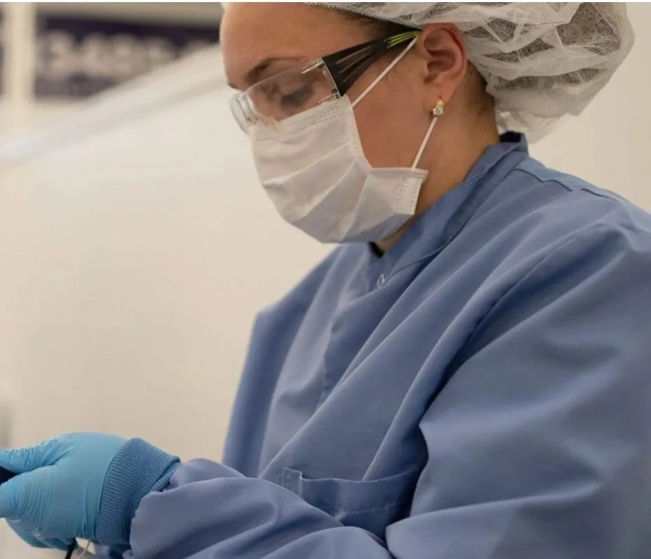Technician in sterile gown and gloves working in a clean room