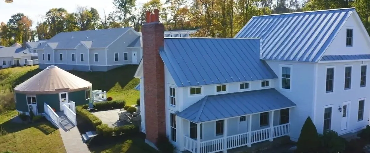 Aerial view of white clapboard buildings with standing seam metal roofs at Newport Academy