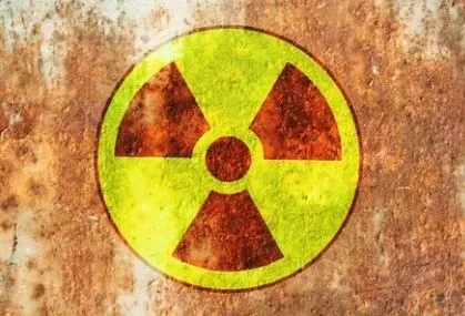 Radiation hazard symbol stencilled on a weathered metal surface
